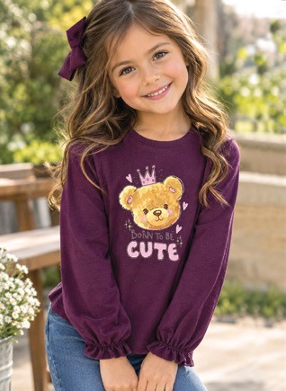 Niña sonriente con blusa color vino con osito bordado y corona
